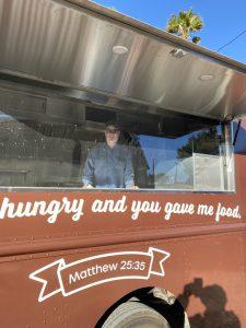 Exterior of Capuchin Order food truck with smiling customer