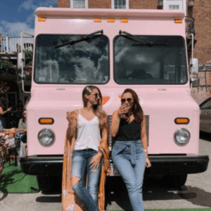Young women drinking wine in front of 90+ Cellars experiential marketing truck