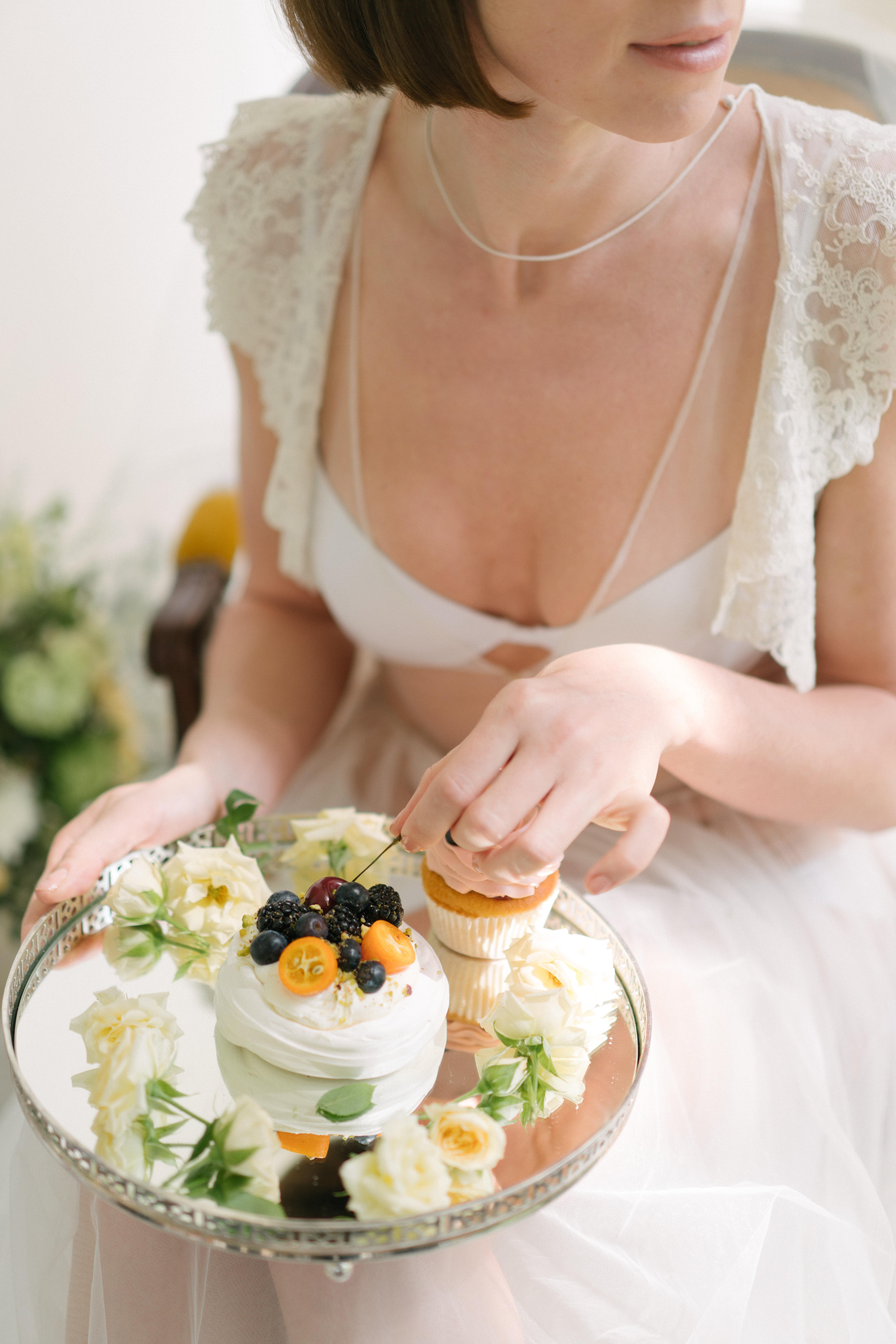 Bride holding silver plate of wedding catering desserts