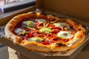 Crispy thin crust pizza in a to-go box