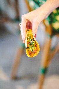 Hand holding a corn street taco