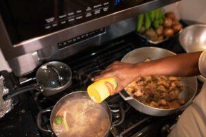 Chef adding ingredients to a boiling pot