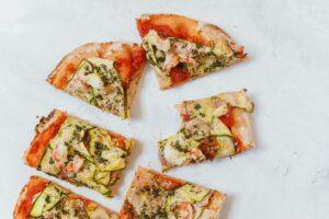Slices of zucchini pizza with one bite taken