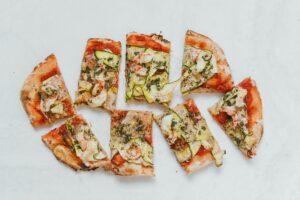 Slices of zucchini pizza on a white background