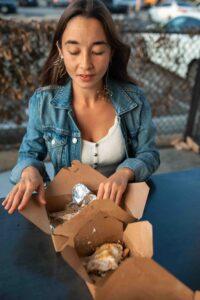 Woman eating food from a to-go container