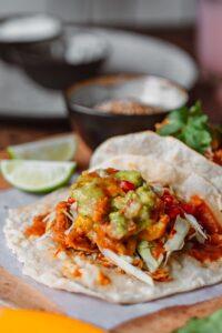 Plated fish tacos topped with guacamole