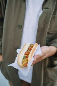 Hand holding a gourmet hot dog