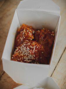 Crispy fried chicken tossed with sauce and sesame seeds