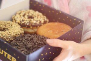 A box of four donuts with different toppings