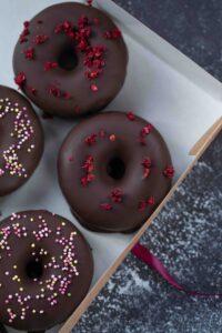 Box of chocolate dipped donuts with colorful sprinkles
