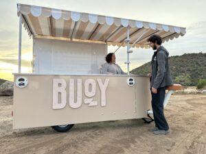 Customers interacting at Buoy experiential marketing vehicle at sunset