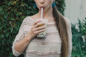 Girl drinking boba tea through a pink straw