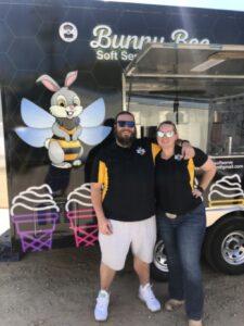 Owners smiling in front of new soft serve ice cream trailer