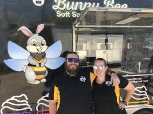 Owners smiling in front of new soft serve ice cream trailer